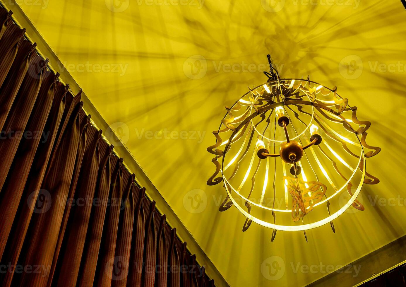 Warm colored light from a modern ceiling pendant lamp photo