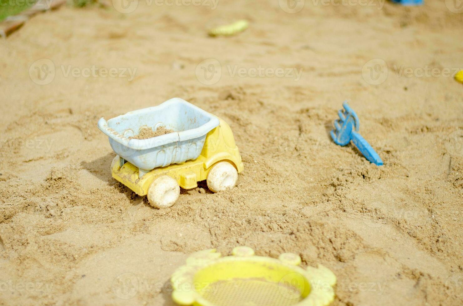 Sandbox toys such as trucks plastic children's toys in the sand,  beach recreation for children. photo