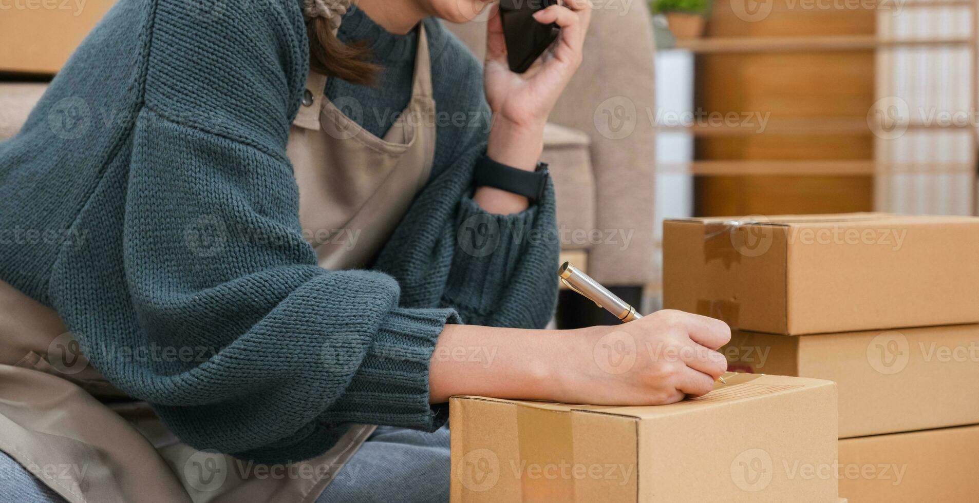 close up, Startup small business entrepreneur SME, asian woman packing cloth in box. Portrait young Asian small business owner home office, online sell marketing delivery photo