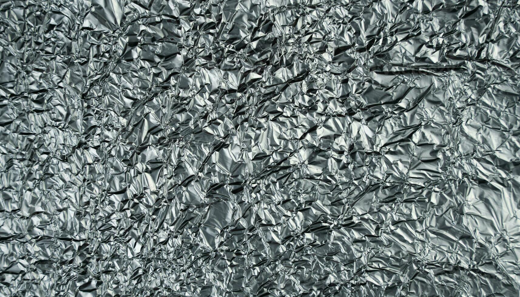 Crumpled silver foil sheet. Abstract background. Banner. Top view. Selective focus. photo