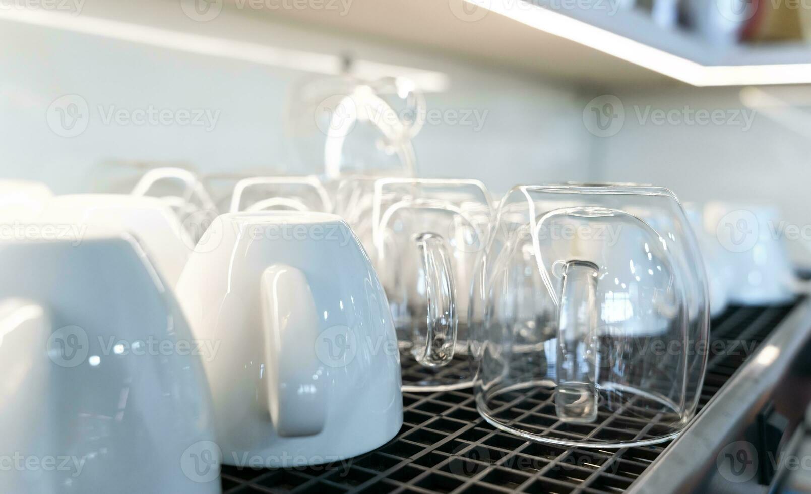 Clean glass and ceramic coffee cups lie upside down on a coffee machine in a cafe. Close-up. Selective focus. photo