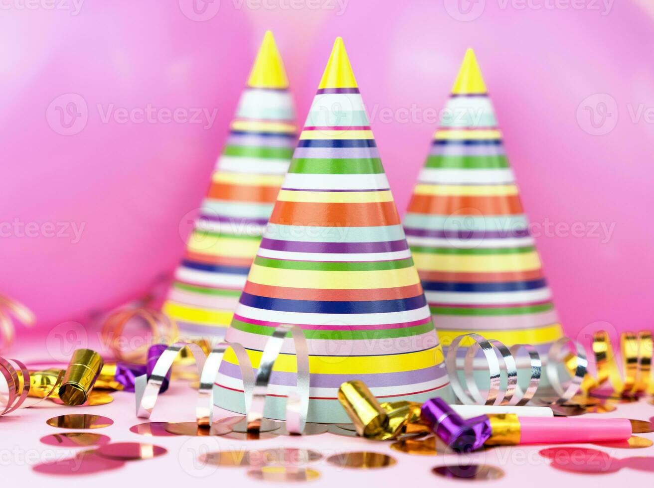 vistoso fiesta sombreros, rosado globos, papel picado para fiesta en rosado antecedentes. de cerca. foto
