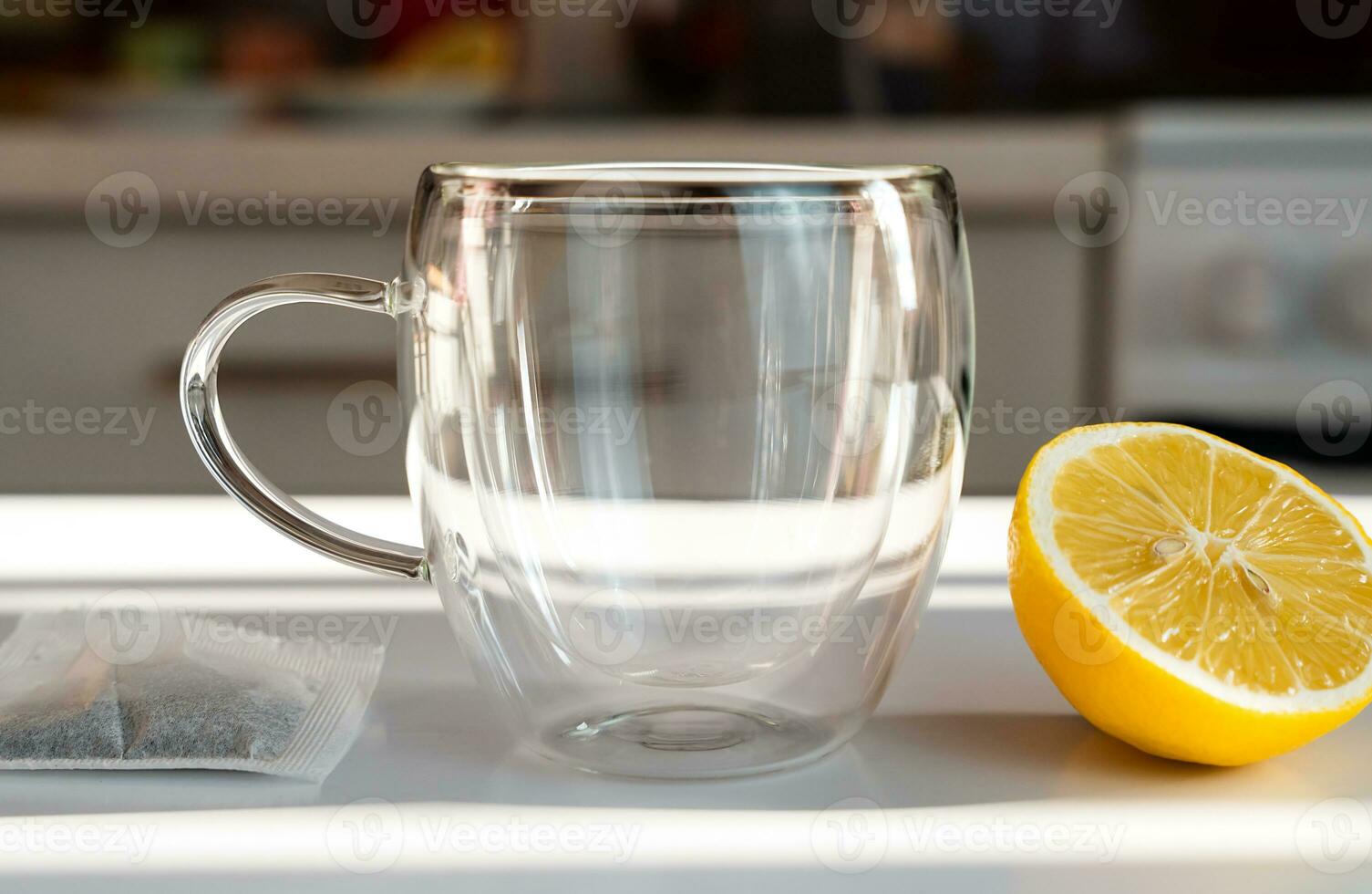Tea drinking concept. Empty cup, tea bag and lemon slice on the table. Close-up. Selective focus. photo