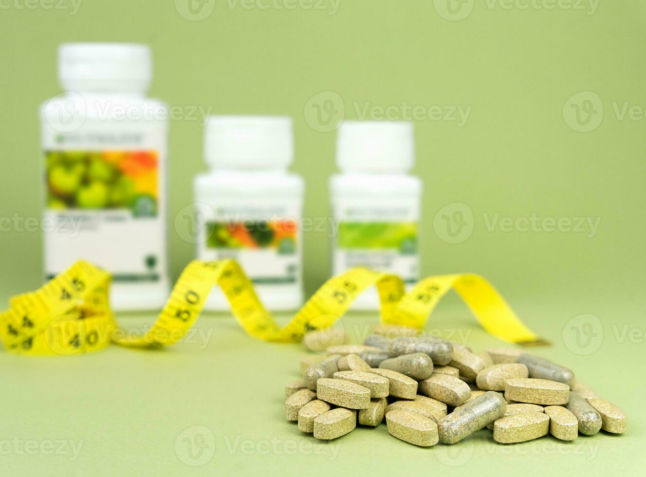 Sports nutrition, supplements. Natural vitamins and supplements on a green background. Close-up. Selective focus. photo