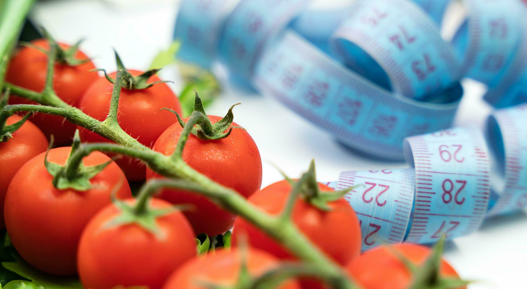 Measuring tape and fresh vegetables on the table. Healthy food concept. Close-up. Selective focus. photo