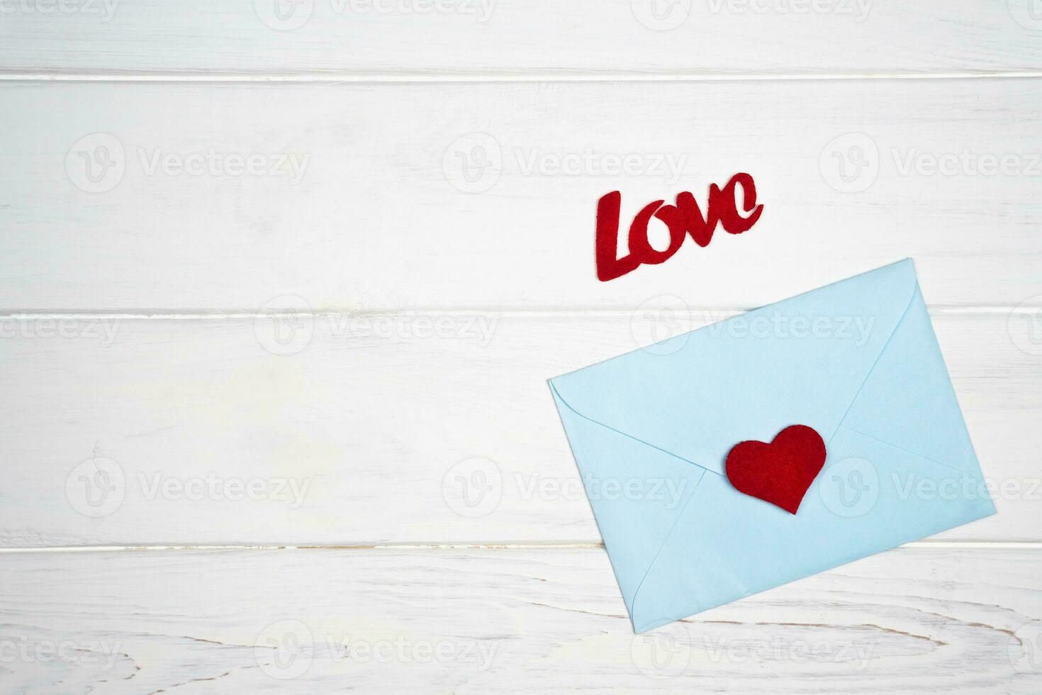 Love romantic message. Envelope with a red heart for Valentine's day on white wooden background. Flatlay. Top view. Place for text. photo