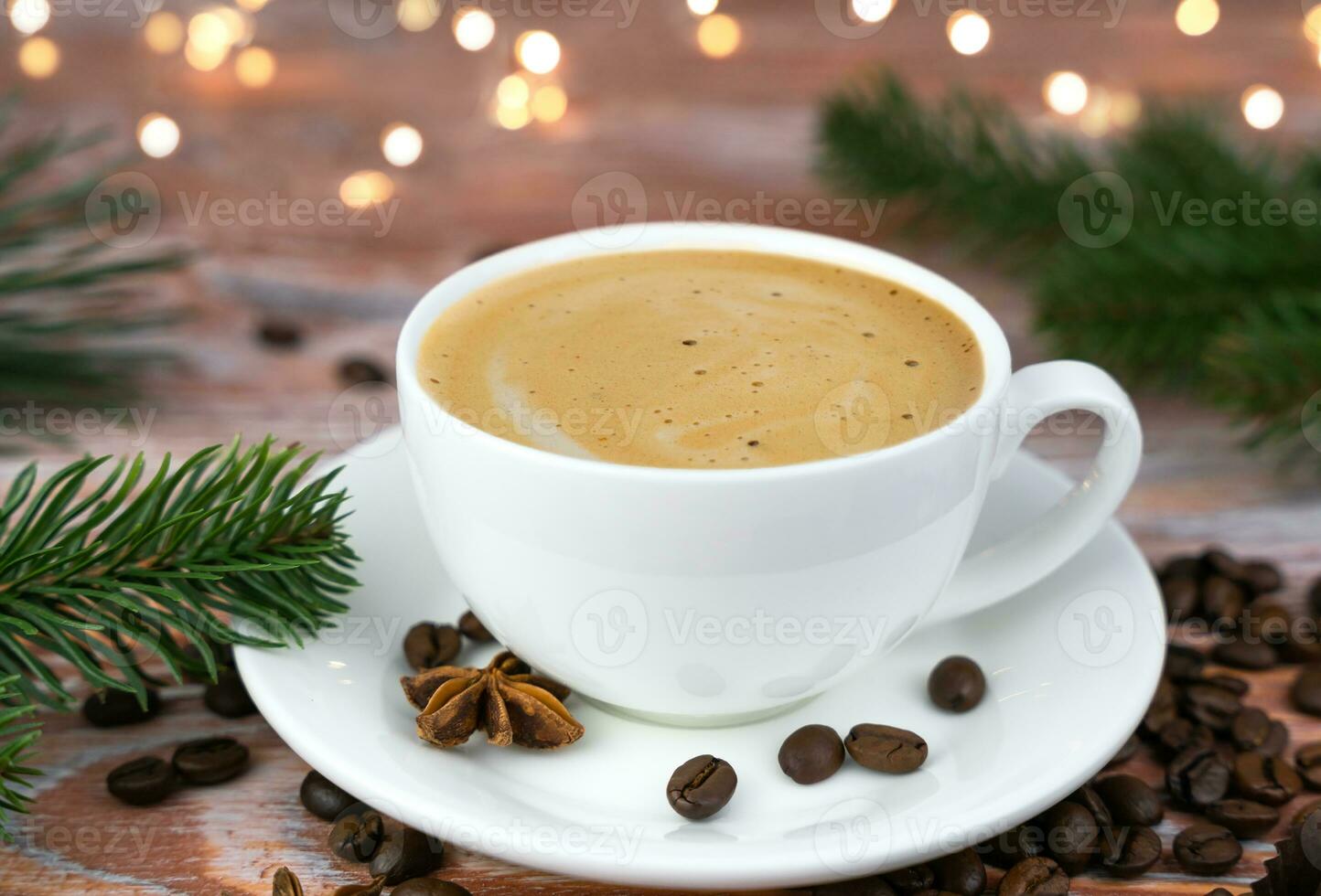 Cup of fresh coffee on the wooden table. Christmas lights garland on background. Festive mood. Close-up. Selective focus. photo