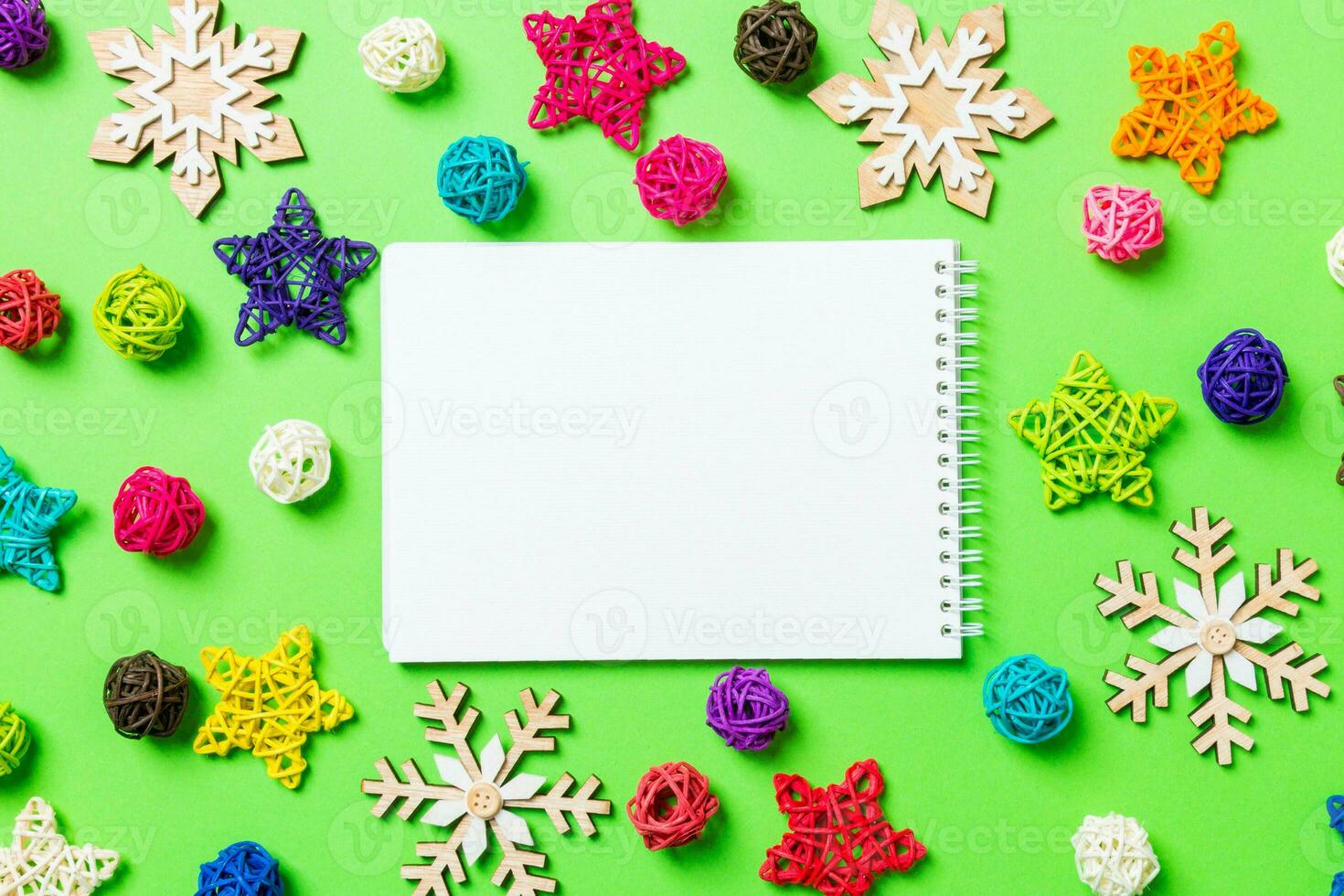 Top view of notebook. New Year decorations on green background. Festive stars and balls. Merry Christmas concept photo