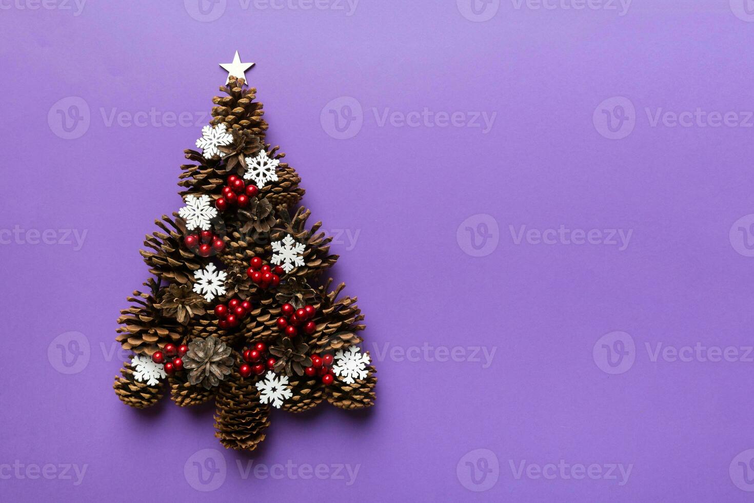 Christmas tree made from natural cones on colored background, view from above. New Year minimal concept with copy space photo