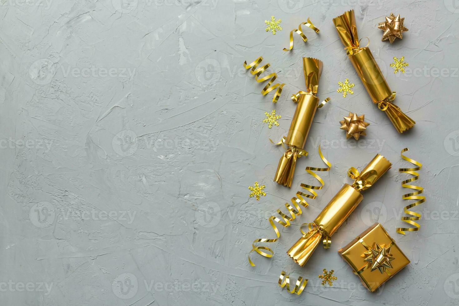 Christmas crackers with shiny confetti on color background, top view, copy space photo