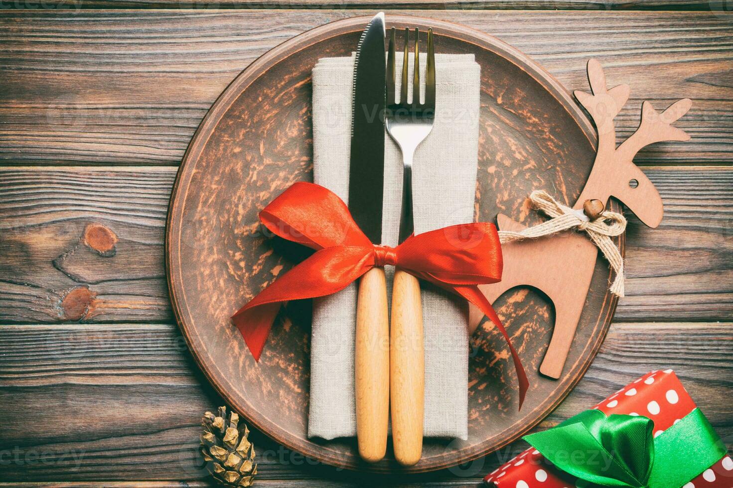 Top view of plate, fork and knife served on Christmas decorated wooden background. New Year Eve concept with copy space photo