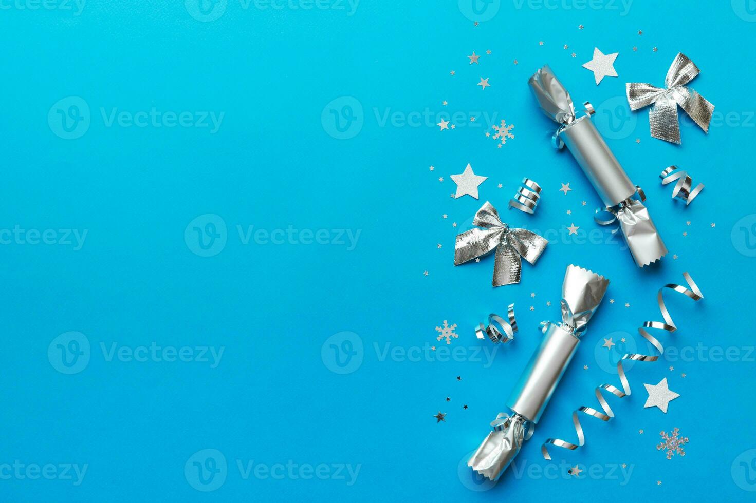 Christmas crackers with shiny confetti on color background, top view, copy space photo