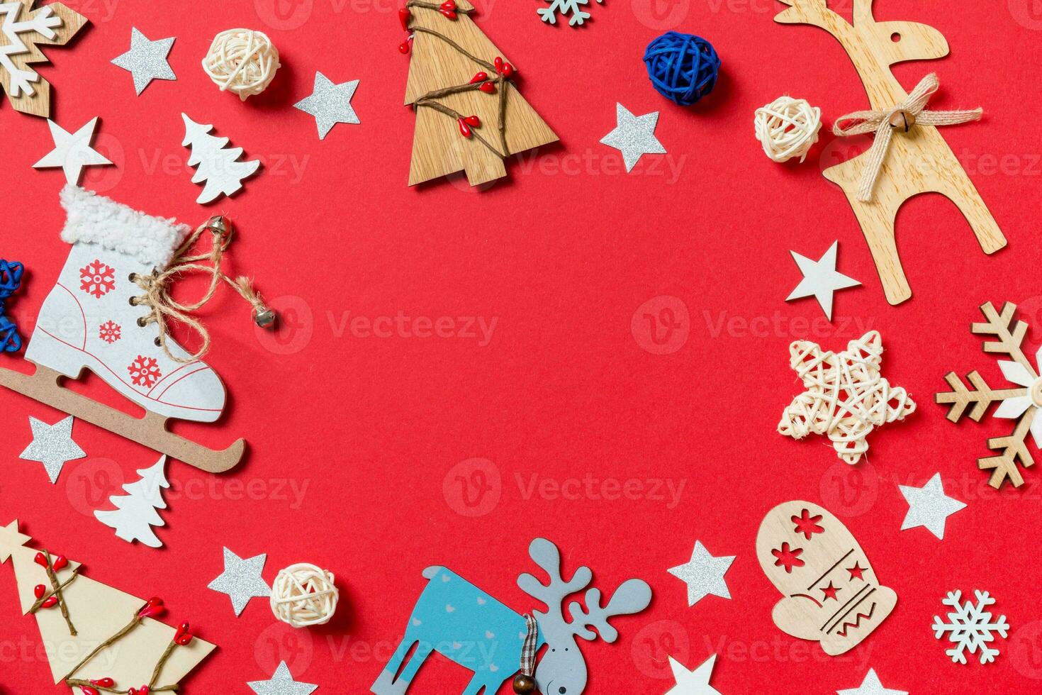 Top view of holiday toys and decorations on red Christmas background. New Year time concept with copy space photo