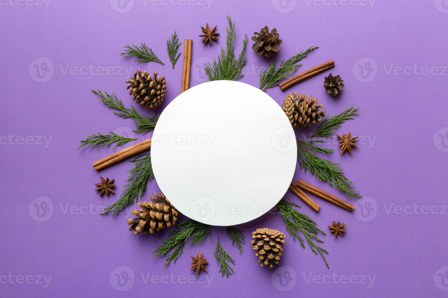 Flat lay Christmas composition. Round Paper blank, pine tree branches, christmas decorations on Colored background. Top view, copy space for text photo