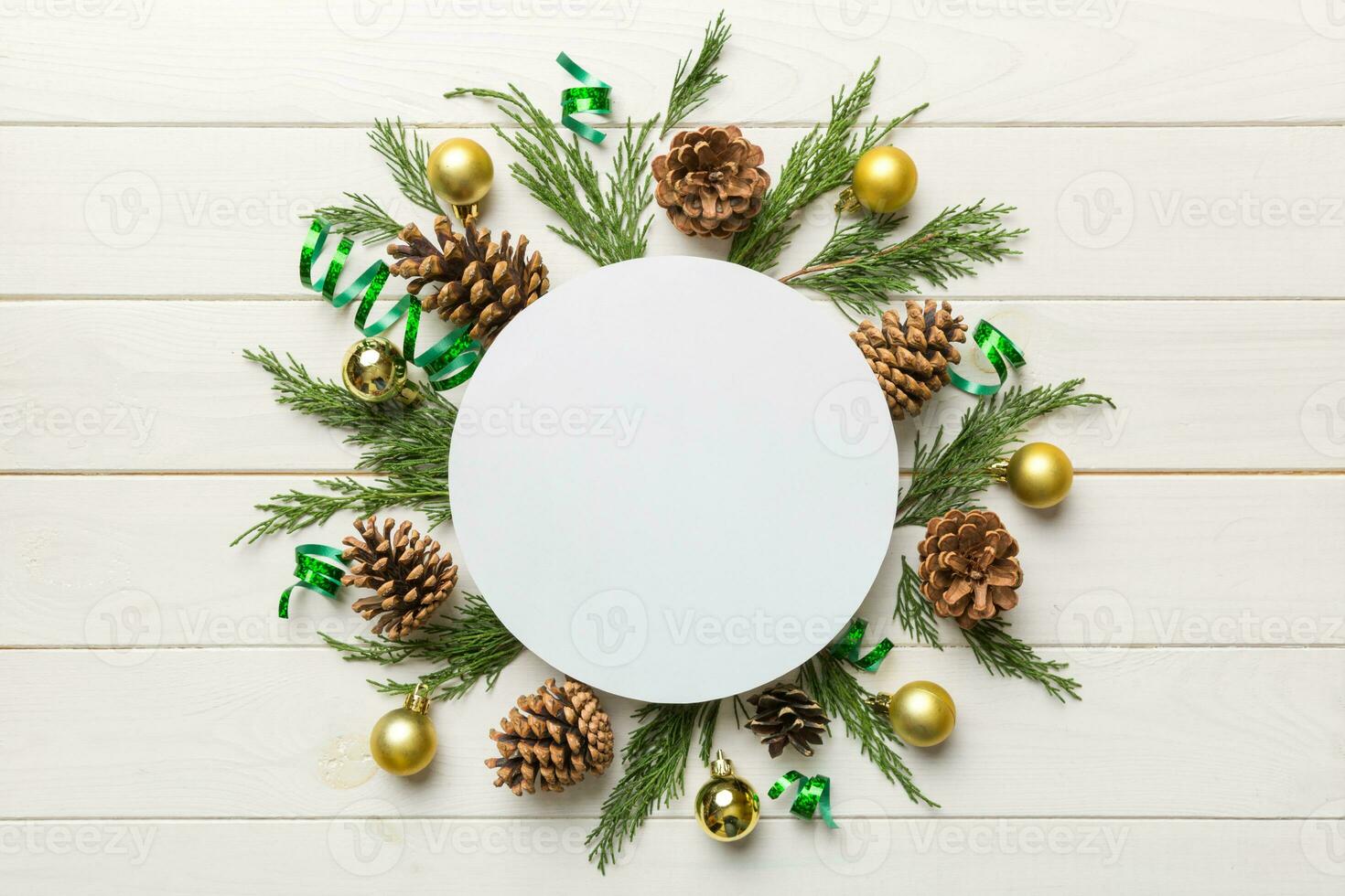 Flat lay Christmas composition. Round Paper blank, pine tree branches, christmas decorations on Colored background. Top view, copy space for text photo