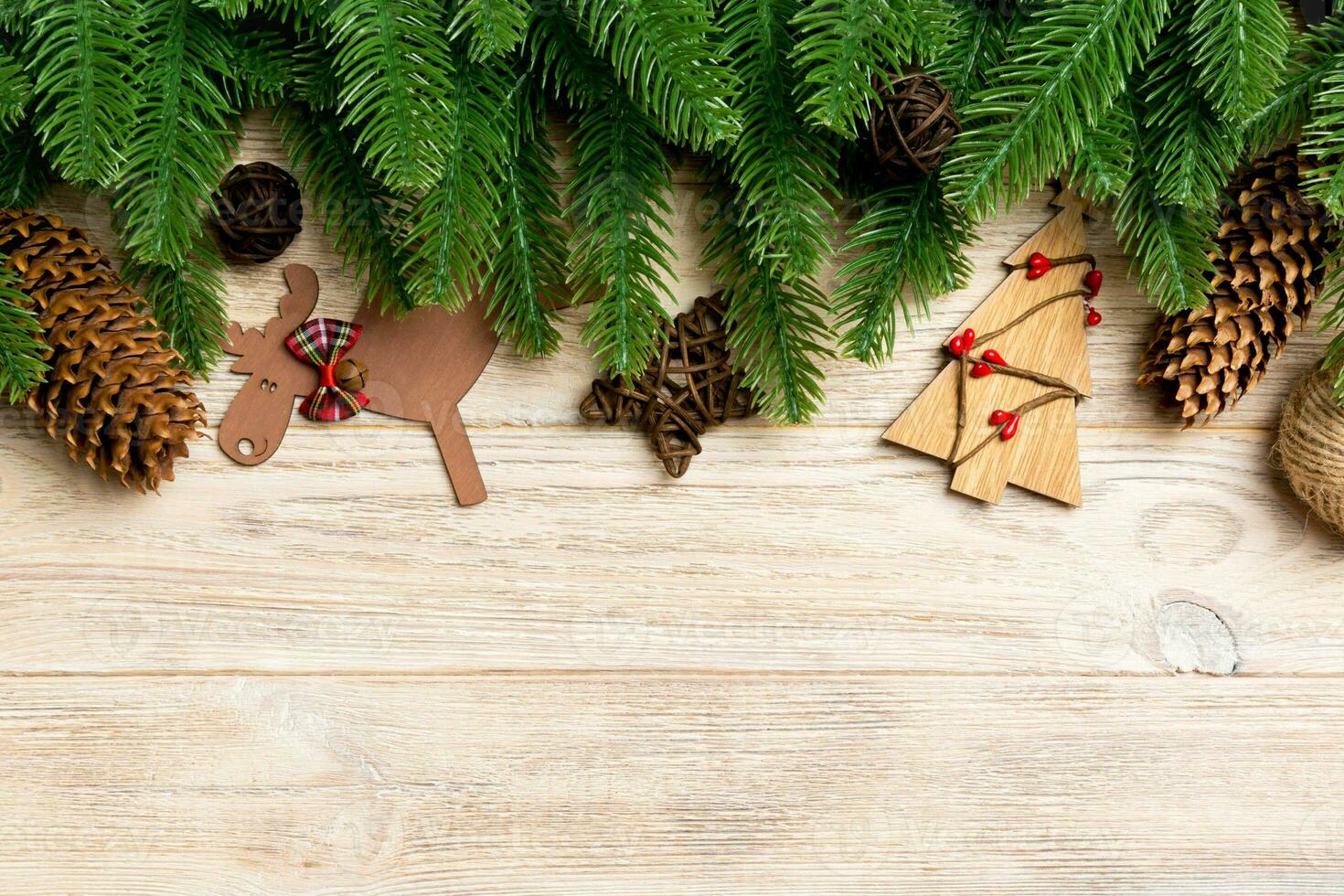 Top view of Christmas toys, decorations and fir tree branches on wooden background. New Year holiday concept with copy space photo