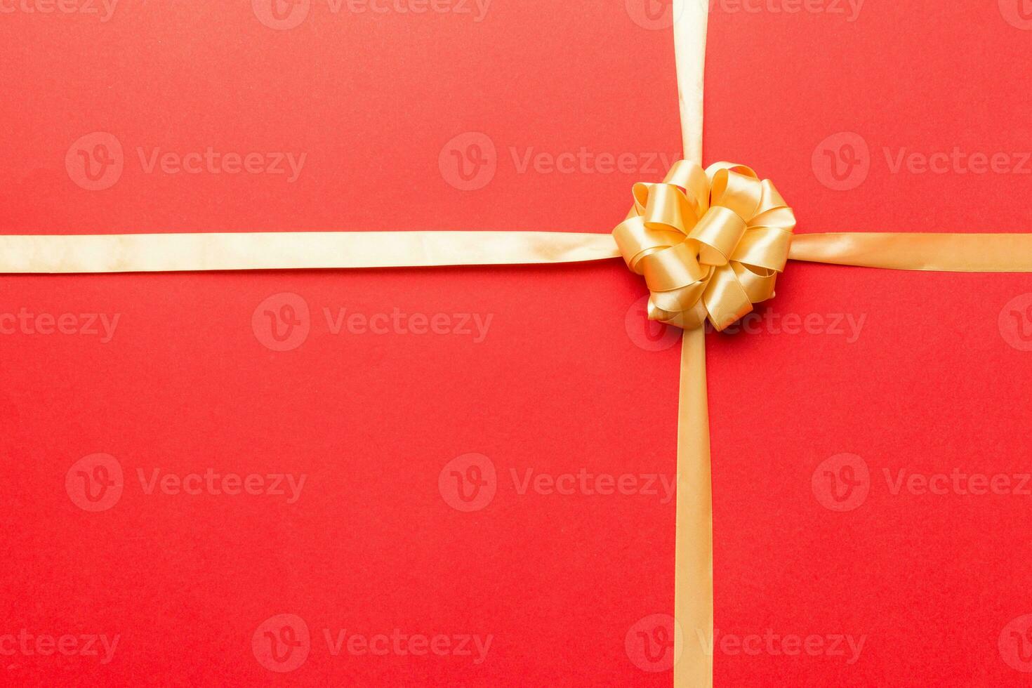 Top view of gold ribbon rolled and yellowbow isolated on colored background. Flat lay with copy space photo