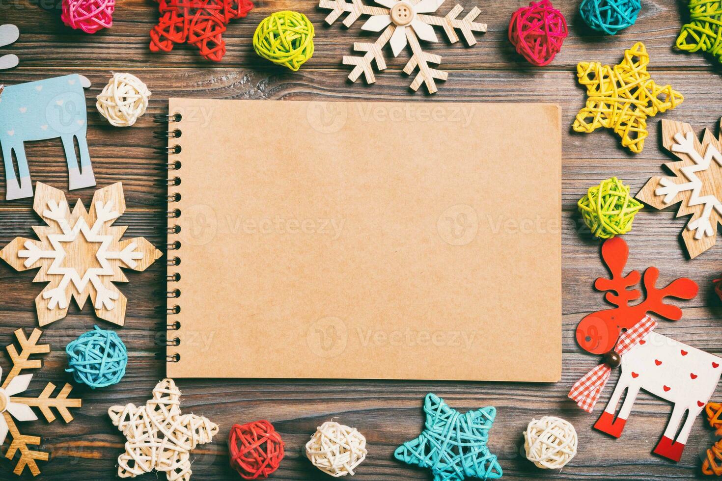 Top view of notebook on wooden background made of Christmas decorations. New Year concept photo