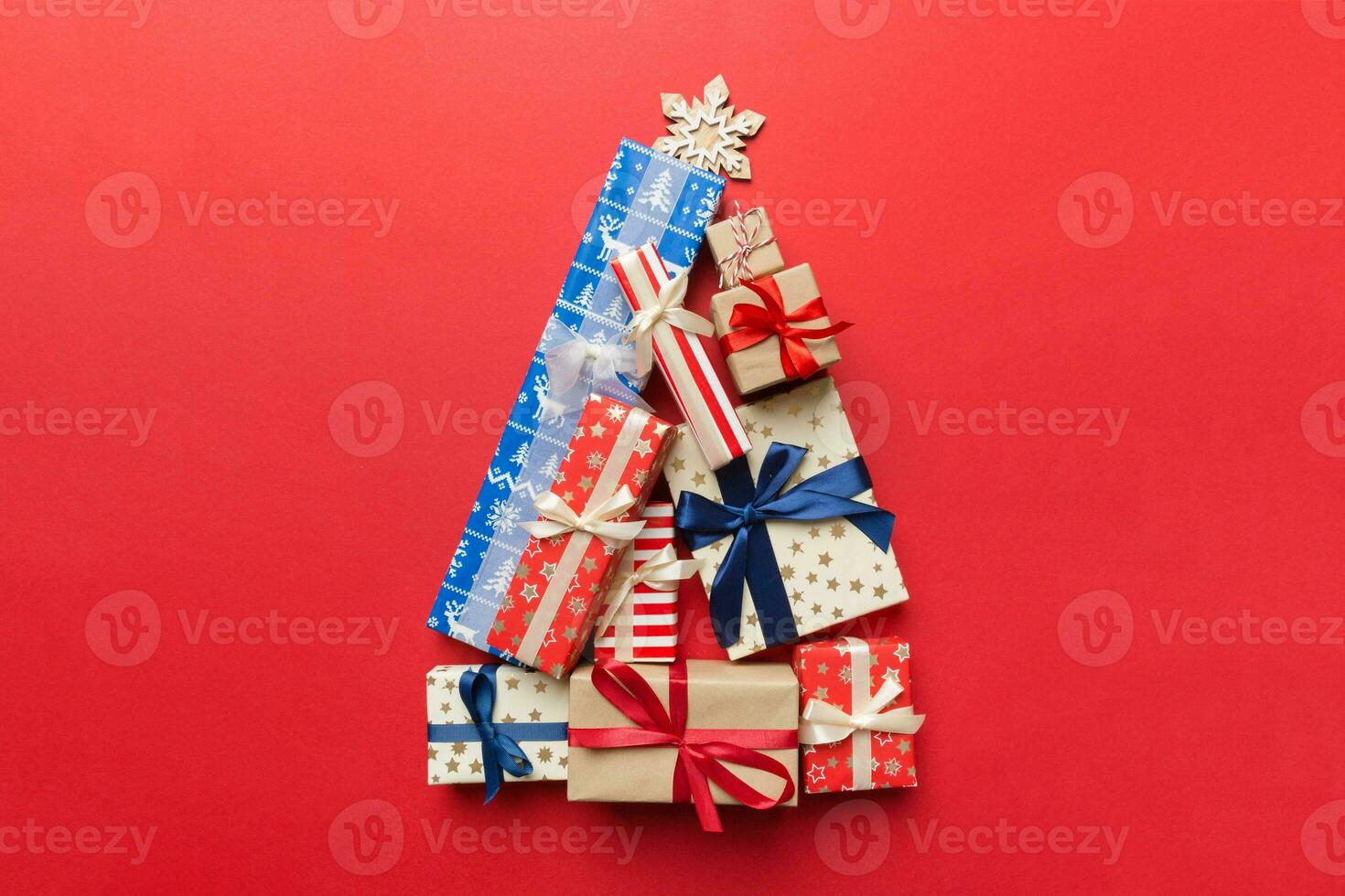 Christmas tree made of beautifuly wrapped presents on colored background, view from above. New Year gift box minimal concept with copy space photo