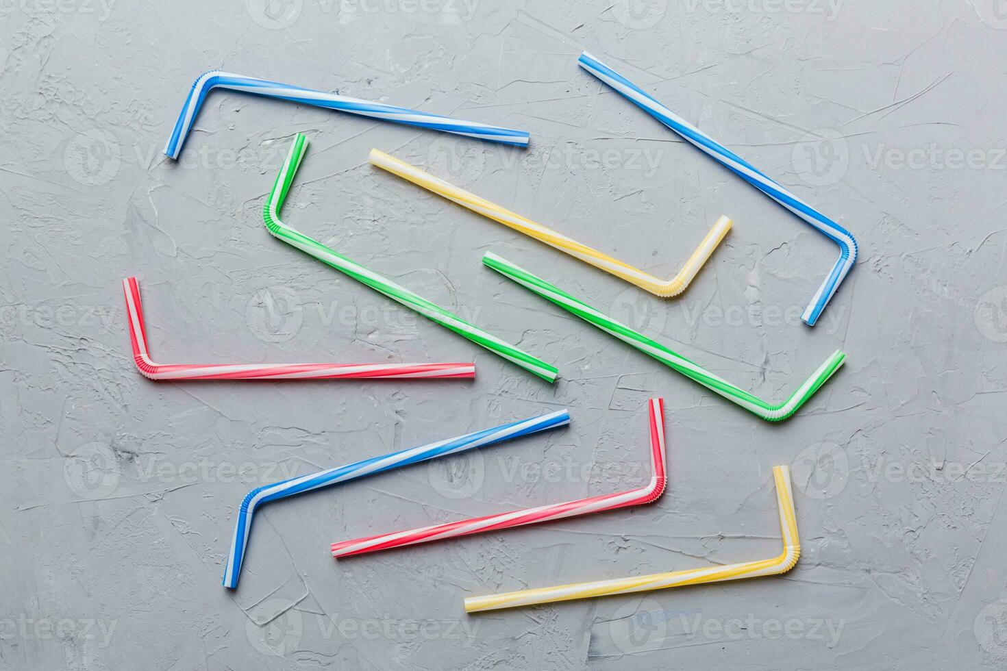 Drinking straws for party on Colored background. Top view of colorful plastic disposable straws for summer cocktails. different straws for juice with copy space photo