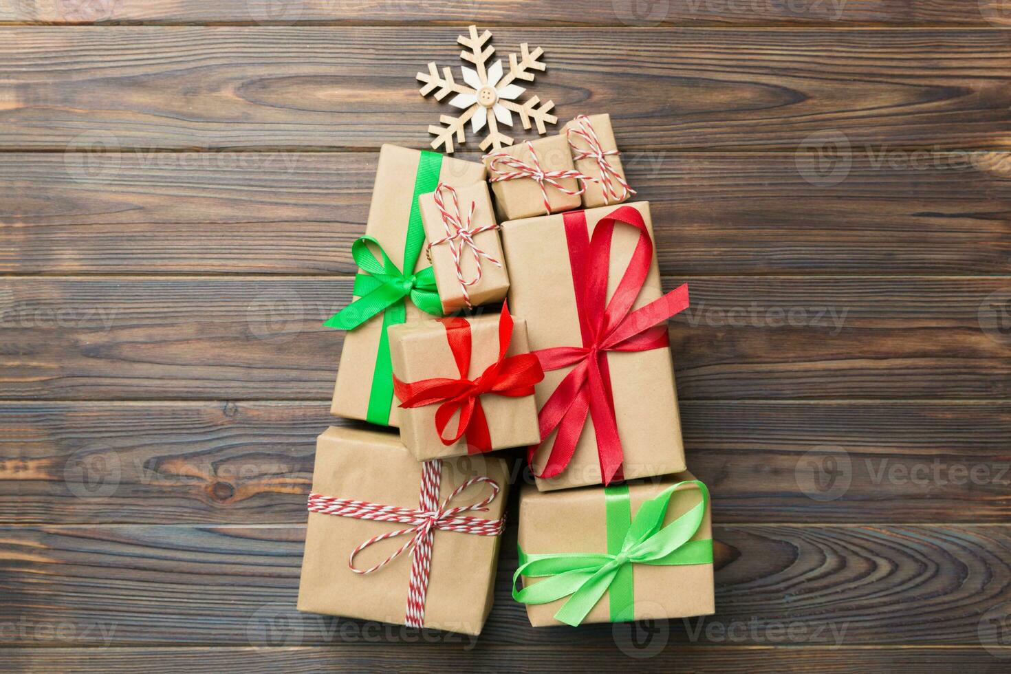 Christmas tree made of beautifuly wrapped presents on colored background, view from above. New Year gift box minimal concept with copy space photo