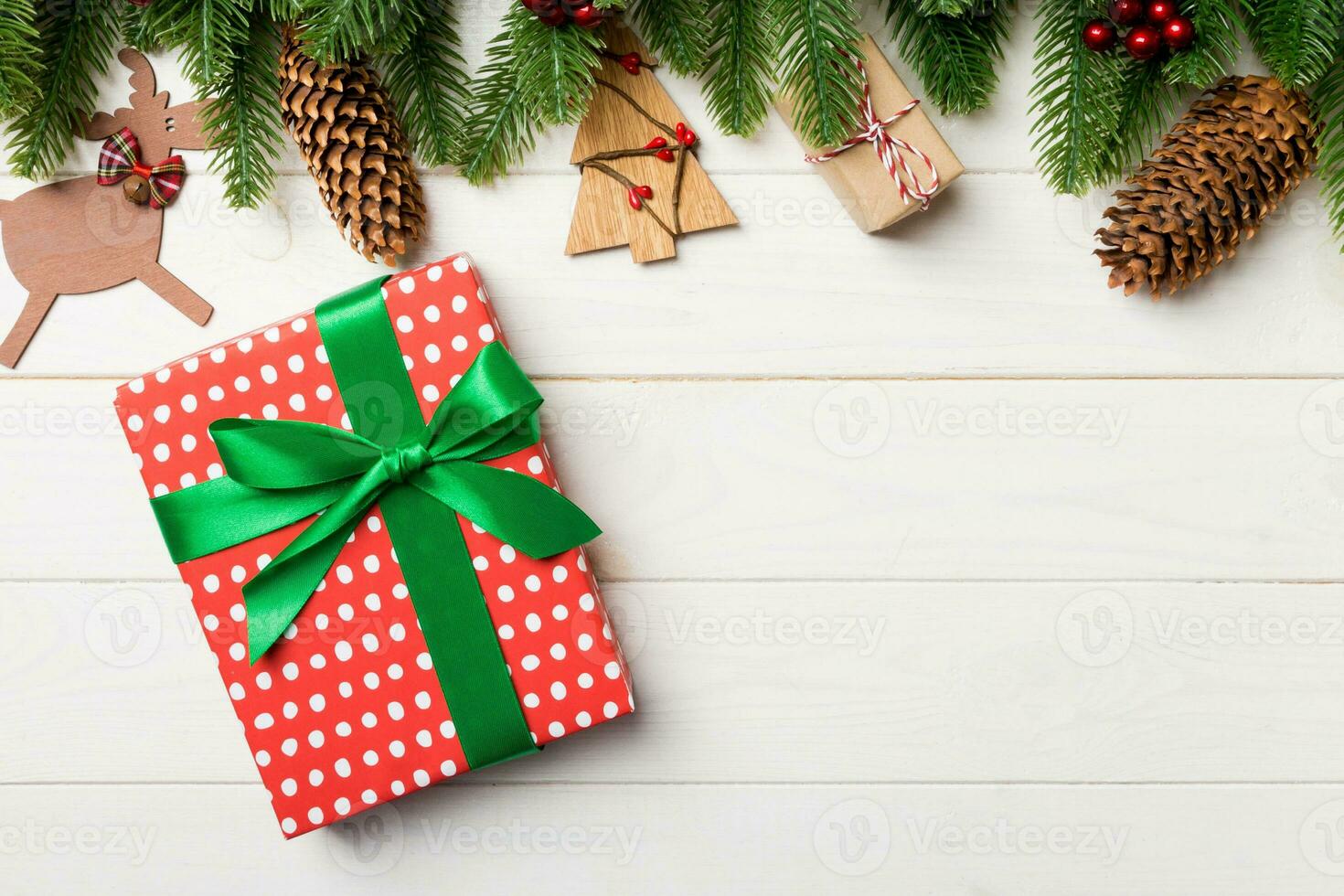 Top view of fir tree, New Year decorations and gift on wooden background. Christmas concept with copy space photo