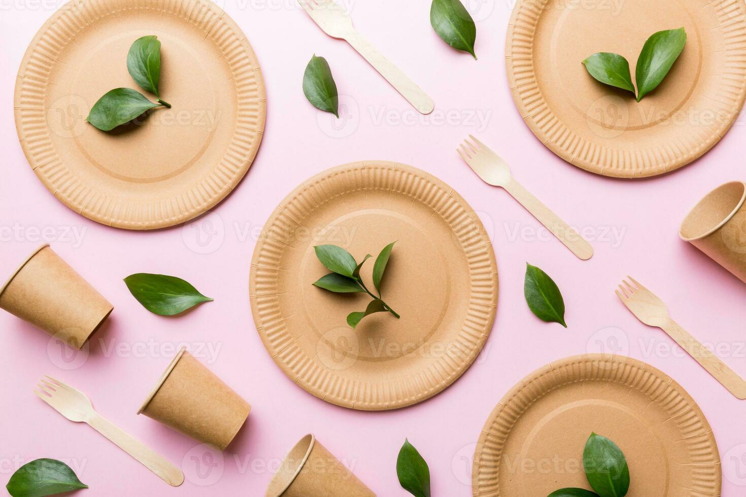 set of empty reusable disposable eco-friendly plates, cups, utensils on light white colored table background. top view. Biodegradable craft dishes. Recycling concept. Close-up photo