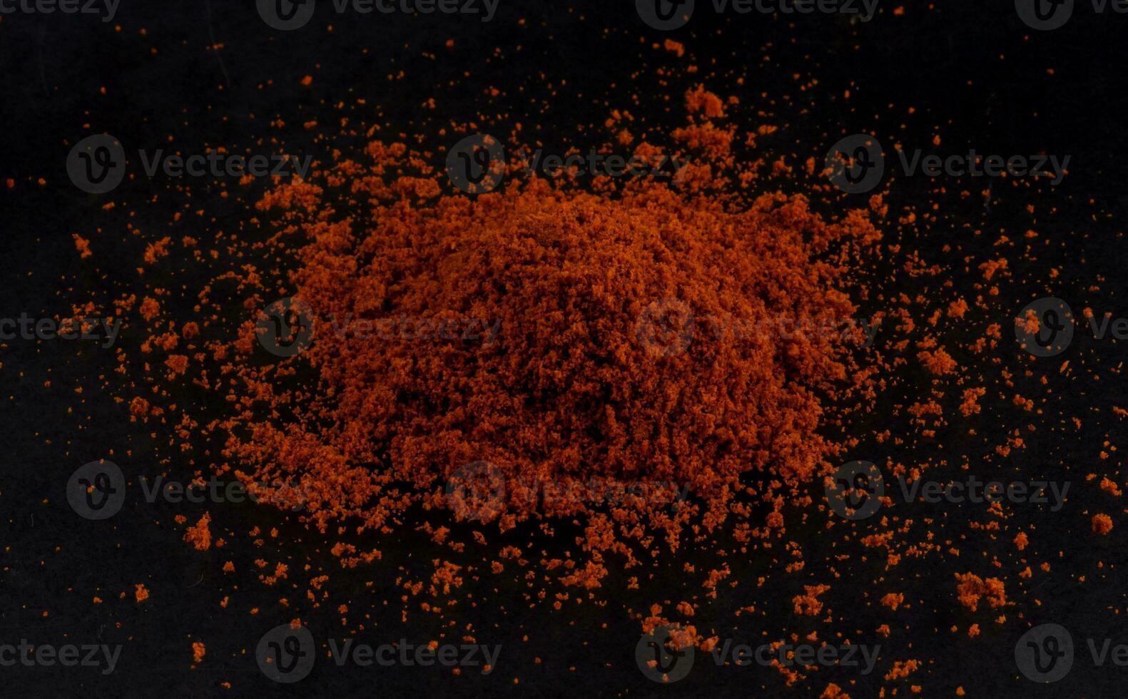 Pile of red paprika powder black background photo