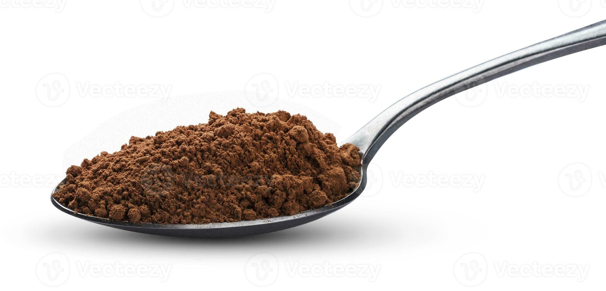 Cocoa powder in spoon isolated on white background. Top view photo