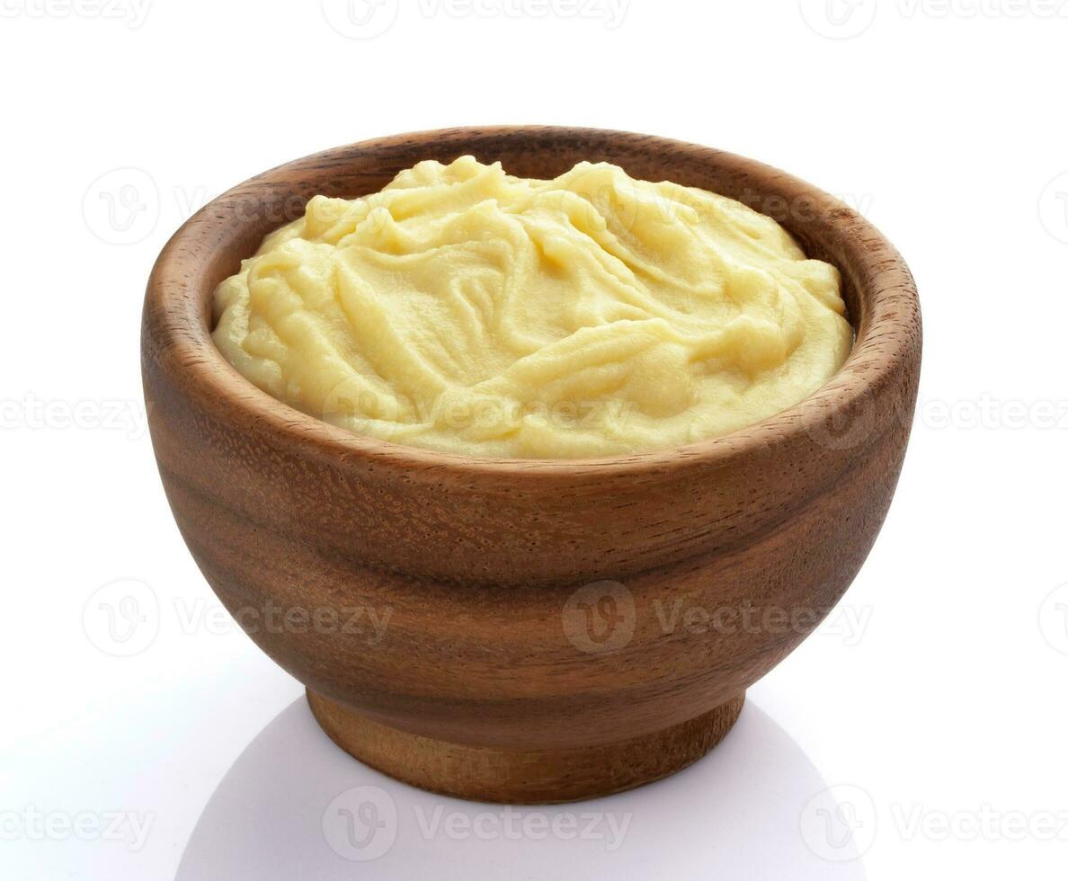 Mashed potatoes in wooden bowl isolated on white background photo