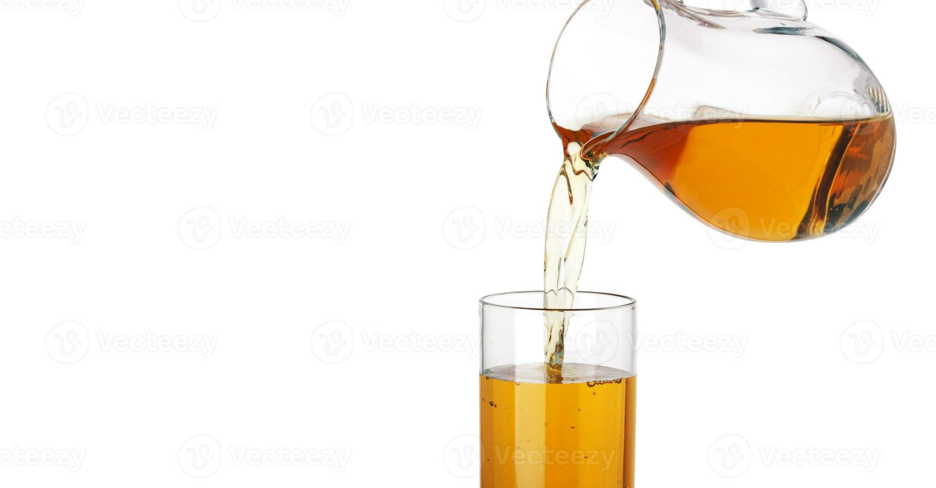 Apple juice pouring from pitcher into glass, isolated on white background photo