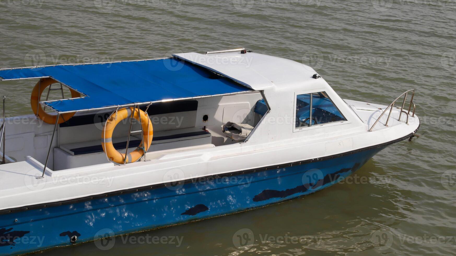 Small passenger motor boat with nobody inside docking, parking or floating in the water. photo