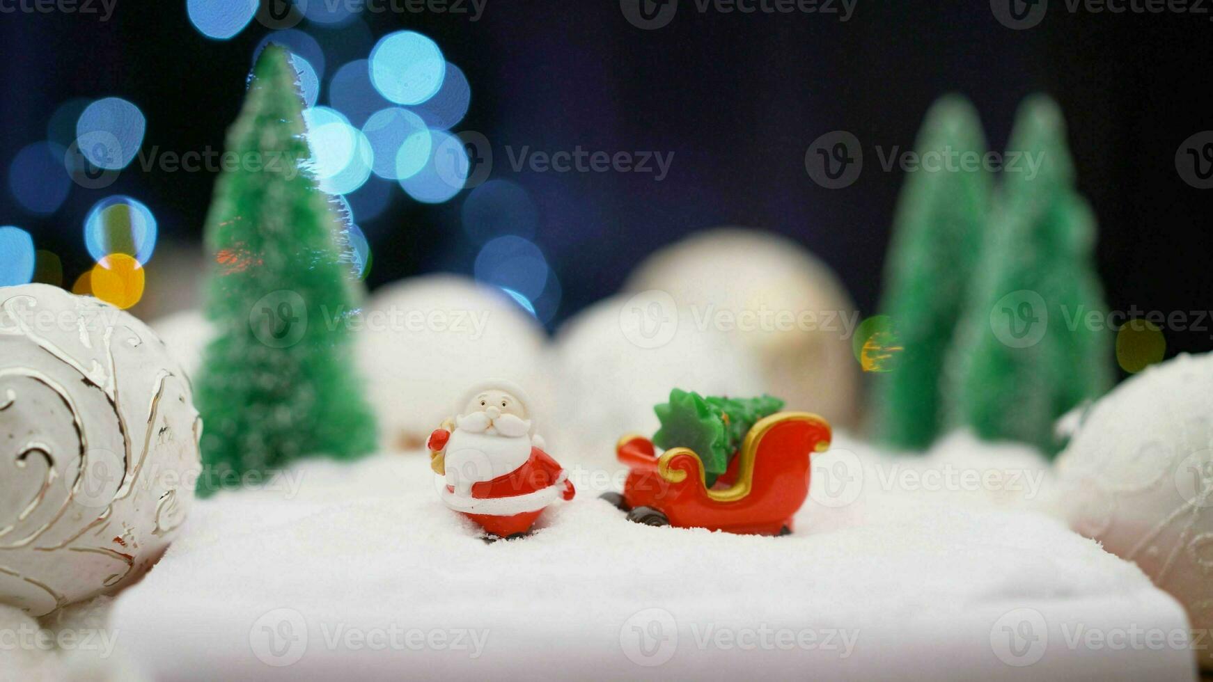 Christmas toy on garland background. Toy Santa Claus on the background of light bulbs. Christmas background Santa Claus with a gift. photo