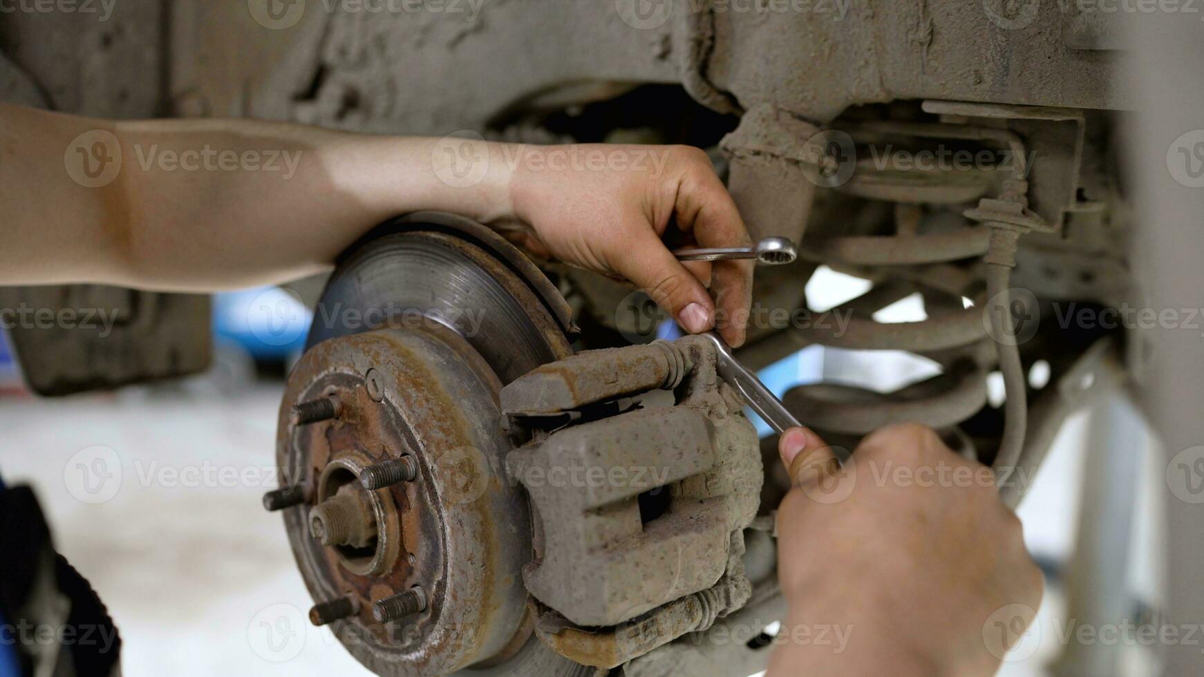 Car brake part in the garage, car brake disc without wheels. Car suspension. Current car repair. Replacement of brake pads in a car service. photo