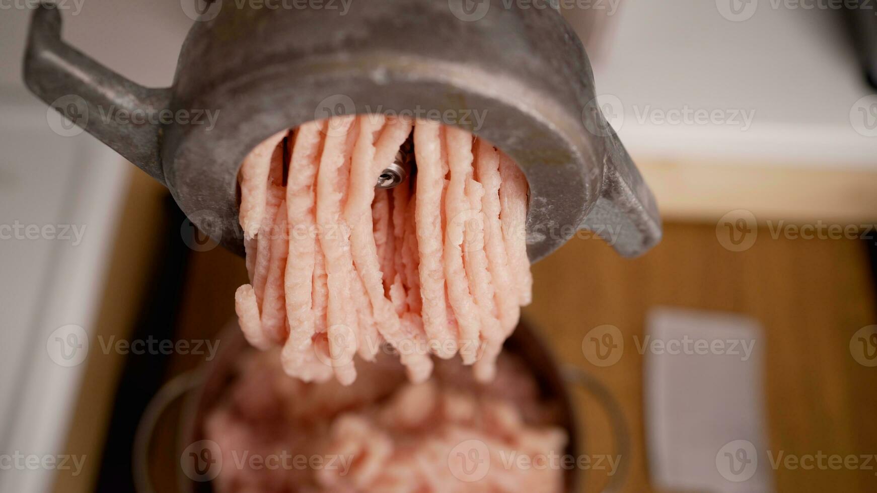 Chicken fillet in a meat grinder. Cooking minced chicken fillet with a household electric meat grinder. photo