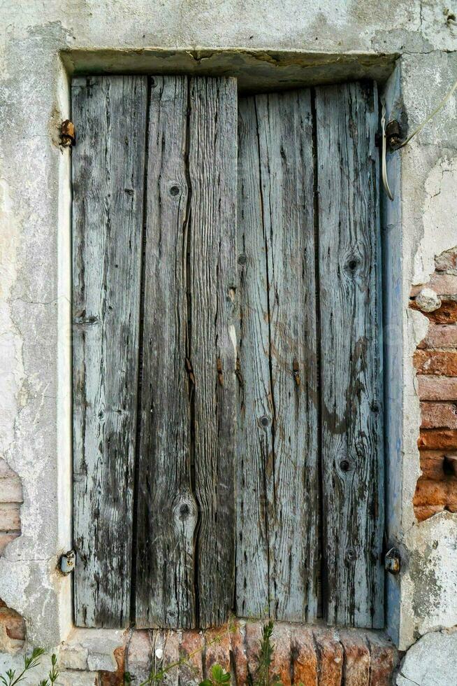 old wooden window with wooden shutters in a brick wall photo