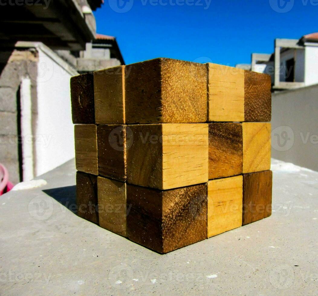 a wooden cube sitting on top of a concrete surface photo
