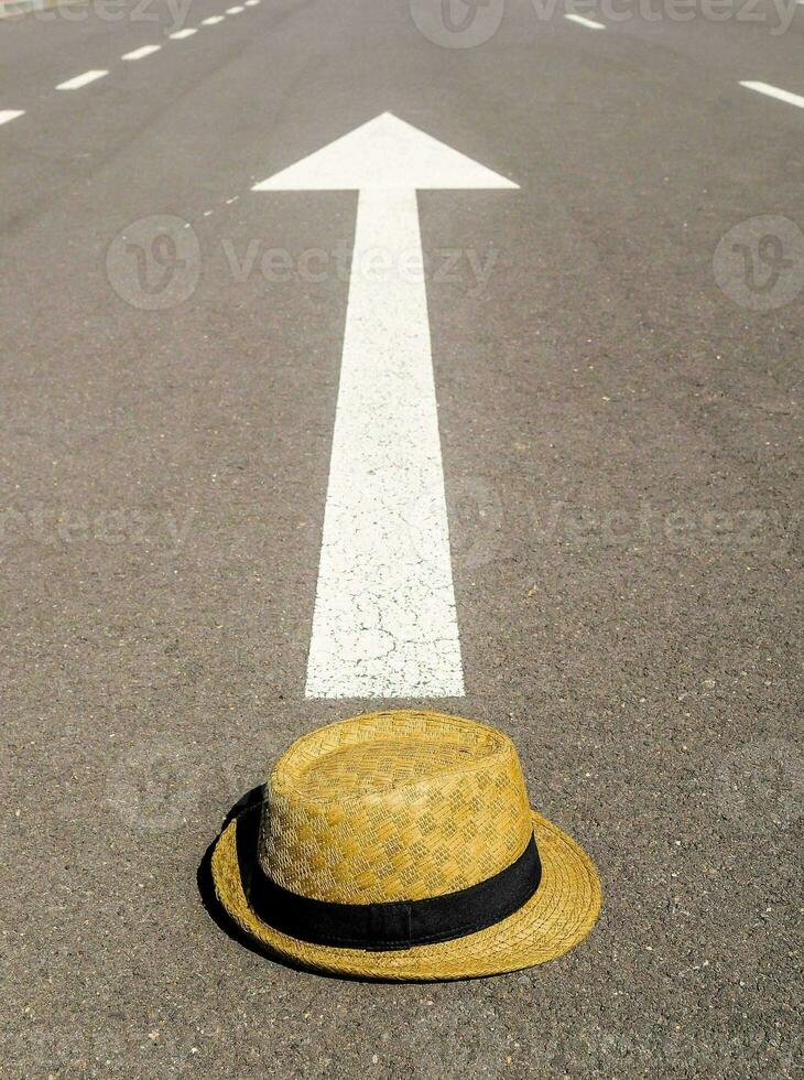 a hat sits on the road with an arrow pointing to it photo