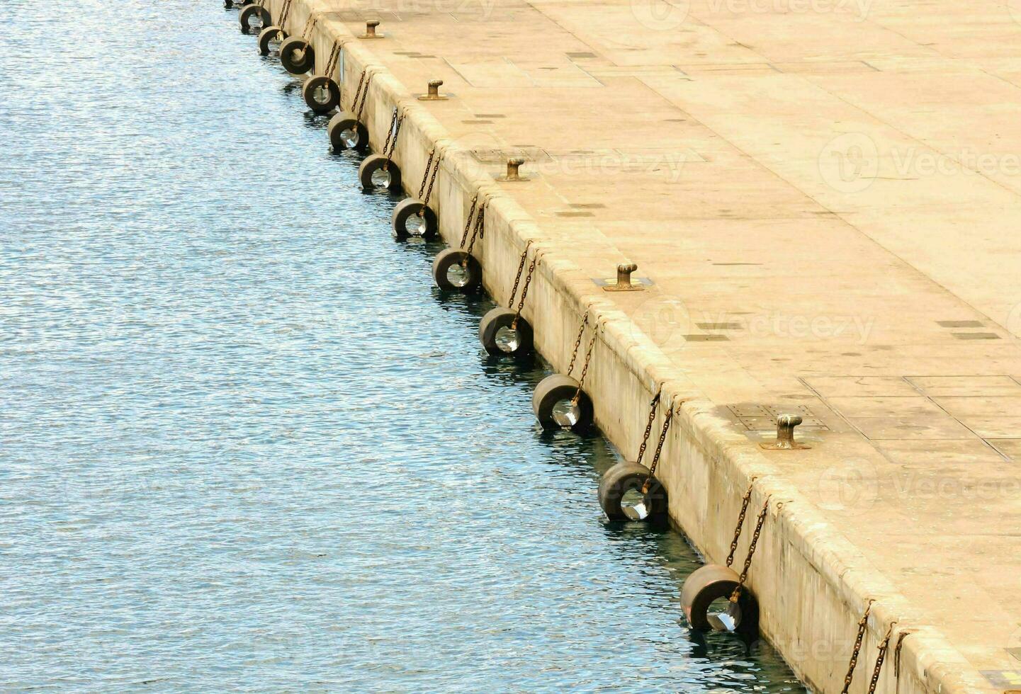 a row of tires on the side of a dock photo