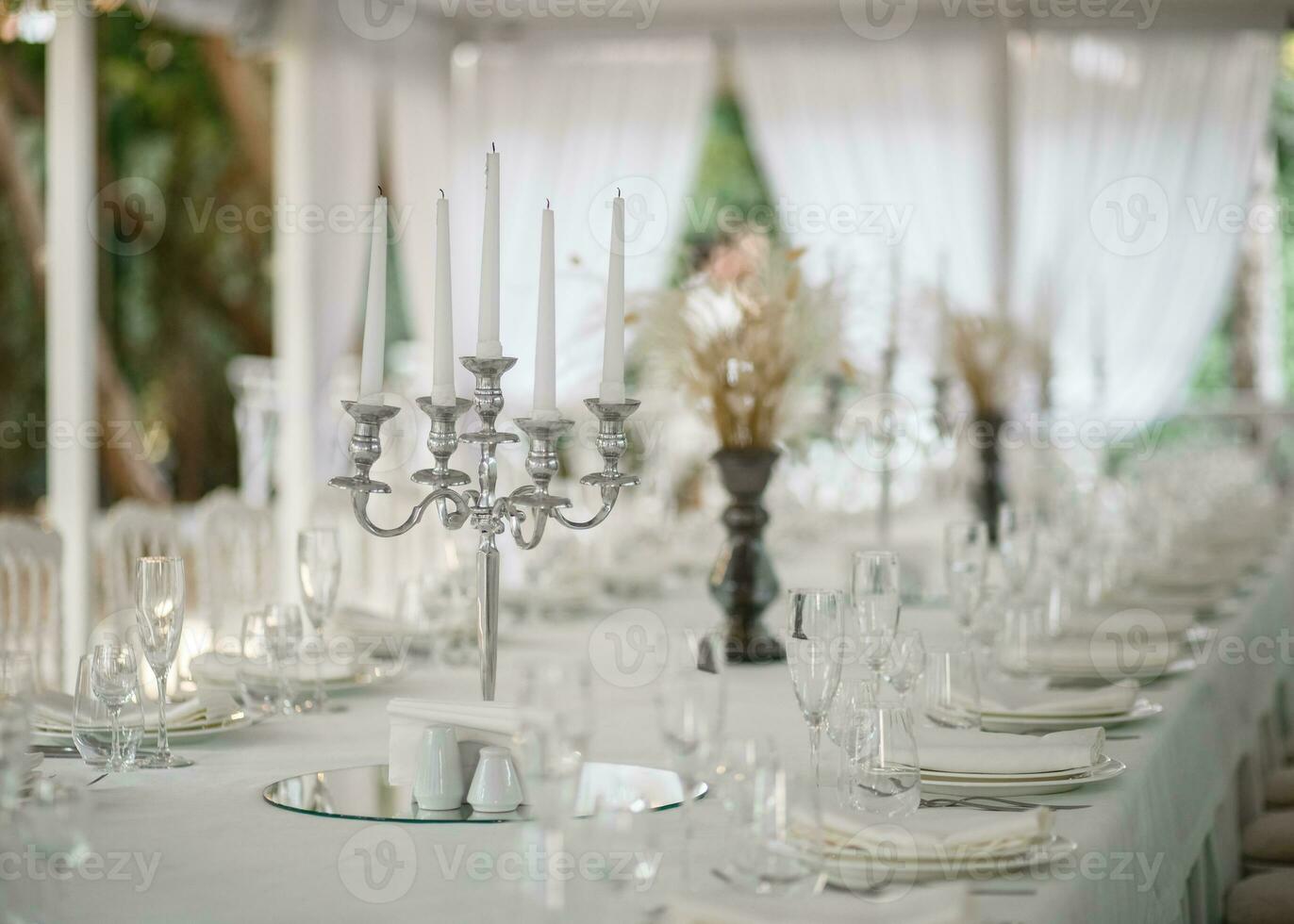 Softfocus chandelier on white tablecloth. White curtains background. photo