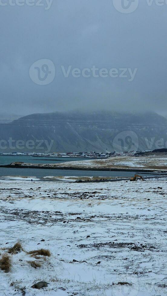 Frozen natural scenery in iceland with frosty cold landscape in nordic region, massive snowy mountains and lands. Winter wonderland roadside environment with highlands and cliffs. photo