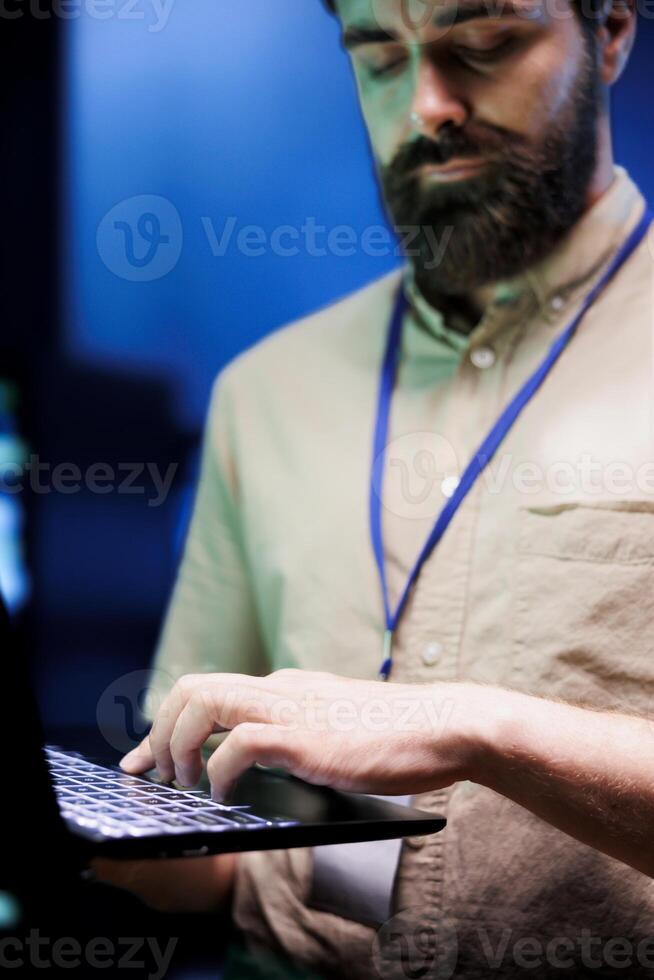 Engineer maintenancing server rigs to optimize them for data processing requirements of AI workloads. Worker inspecting neural network high tech facility used for machine learning photo