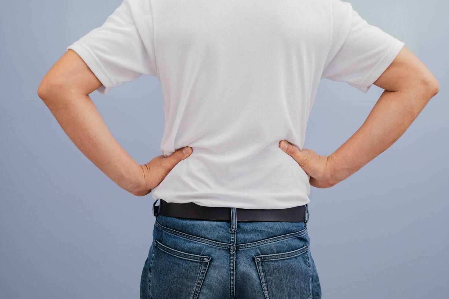 Man wearing white shirt showing back pain photo