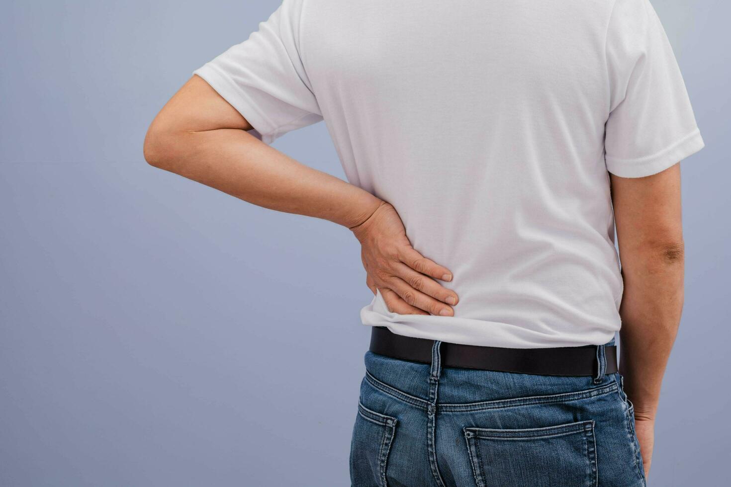 Man wearing white shirt showing back pain photo