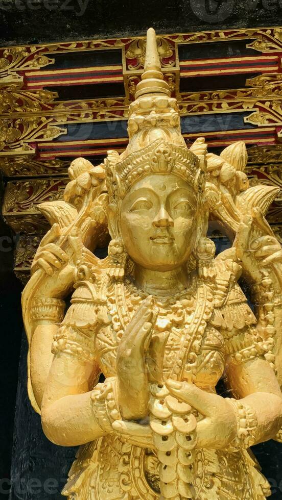 Balinese Hindu God golden Shiva Durga statue on a sacred Hindu temple in Indonesia photo