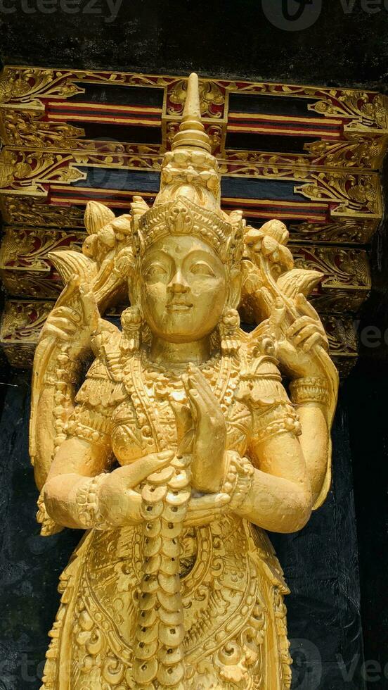 Balinese Hindu God golden Shiva Durga statue on a sacred Hindu temple in Indonesia photo