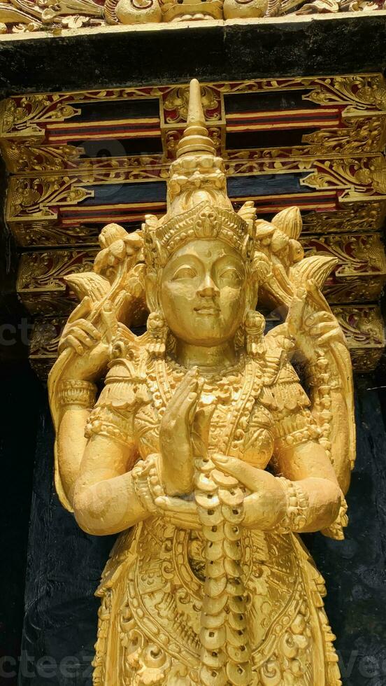 Balinese Hindu God golden Shiva Durga statue on a sacred Hindu temple in Indonesia photo