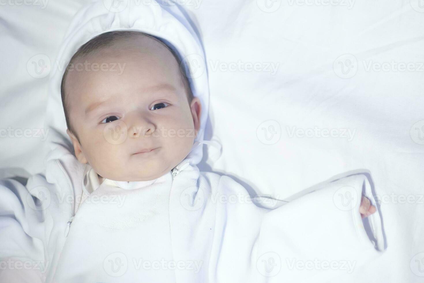 Little cute newborn baby boy looking coriously at camera photo