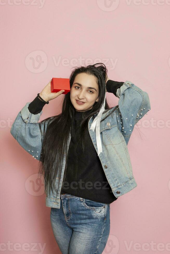 Young and happy woman holds a giftbox. Female received valentines present. Valentines day, Birthday, Anniversary, Holiday celebration photo