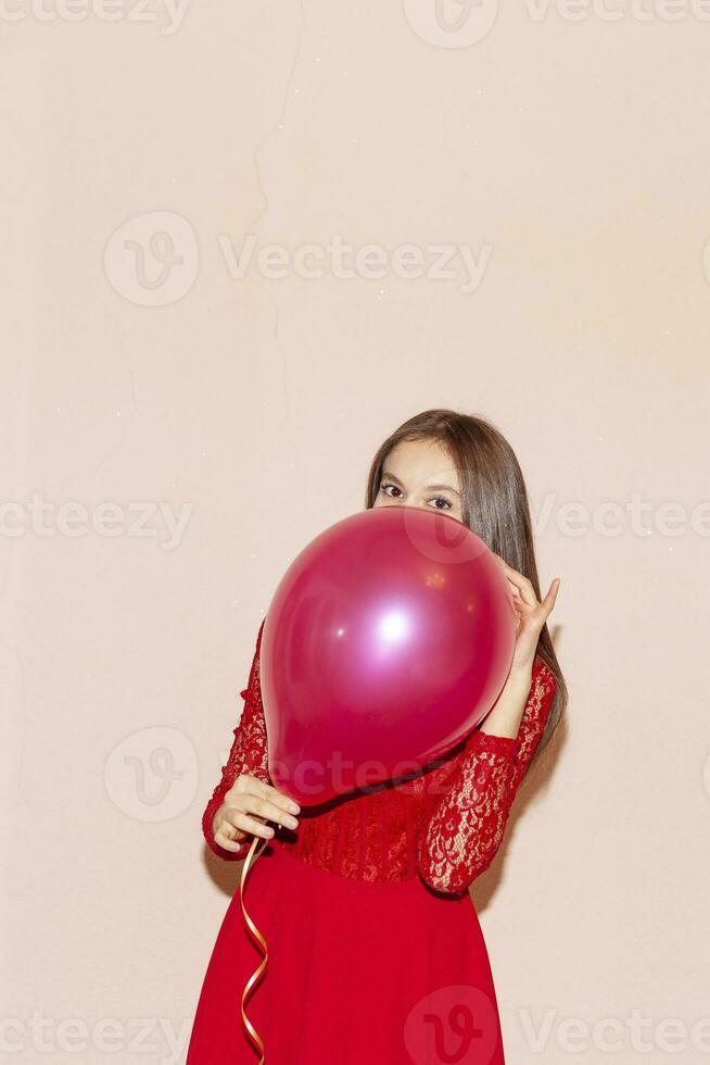 beautiful girl covers her face with air balloon. valentines day, birthday, womens day, anniversary, holiday celebration concept photo